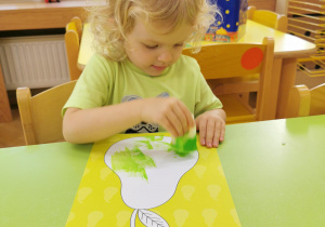 dzieci stemplują ilustrację gruszki gąbką umoczoną w farbie