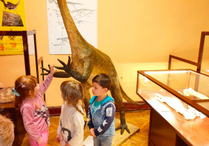 Dzieci oglądają eksponaty muzealne.