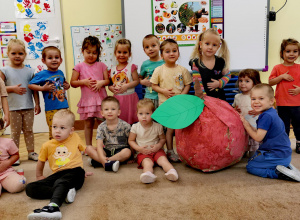 zdjęcie grupowe z ogromnym jabłkiem z papieru pomalowanym przez dzieci