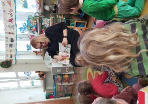 Pani Ola pokazuje obrazek z książki dzieciom siedzącym przed nią