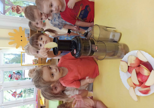 Dzieci wyciskają sok z jabłek.