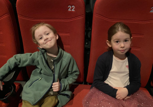 chłopiec i dziewczynka siedzą w fotelach i czekają na film