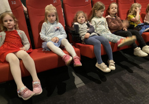 dziewczynki siedzą w fotelach i czekają na film