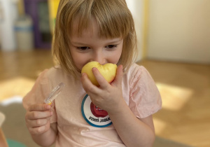Dziewczynka wącha jabłko