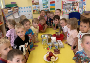 Dzieci stoją przy stole z produktami do ciasta