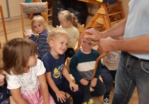 Prowadzący prezentuje dzieciom węża zbożowego.
