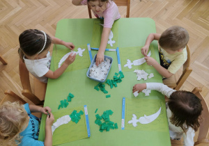 dzieci wykonują pracę plastyczną - pietruszkę
