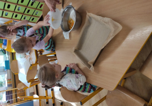 Dzieci wsypują składniki do miski