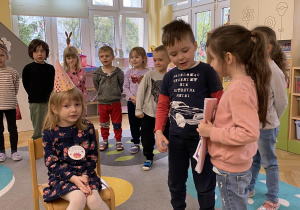 dziewczynka i chłopiec wręcza dyplom jubilatce