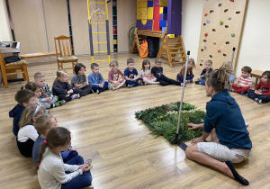 instruktor pokazuje model łąki a wkoło siedzą dzieci