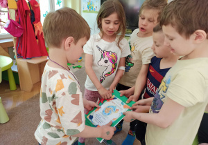 kilkoro dzieci wręcza albumy urodzinowe jubilatom