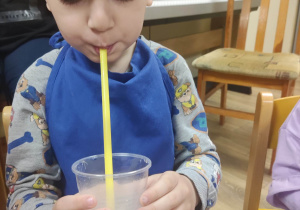 Chłopiec pije sok z suchym lodem.