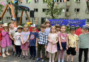 dzieci stoją w ogrodzie przedszkolnym