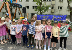 dzieci stoją w ogrodzie przedszkolnym