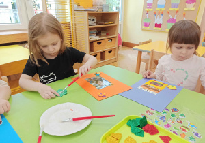Dzieci ozdabiają naklejkami ramkę wokół własnego zdjęcia.