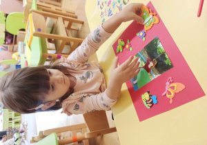 Dzieci ozdabiają naklejkami ramkę wokół własnego zdjęcia.