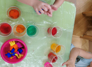 kubki z kolorową wodą zabarwioną przewz dzieci