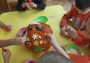 Dzieci dekorują dynię.
