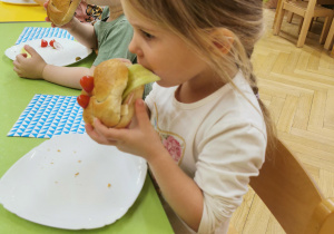 Dziecko zjada kanapkę w kształcie żabki.