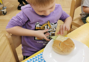 Dziecko zjada kanapkę w kształcie żabki.