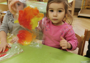 dziecko maluje liście farbą przez folię