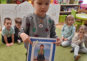 Chłopiec prezentuje obrazek ilustrujący jedno z podstawowych praw dziecka.