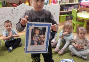 Chłopiec prezentuje obrazek ilustrujący jedno z podstawowych praw dziecka.
