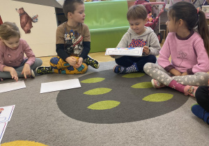 dzieci siedzą na dywanie i omawiają prawa dziecka