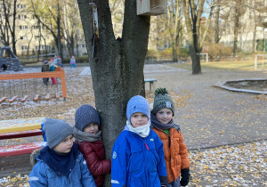 dzieci stoją na dworze pod drzewem