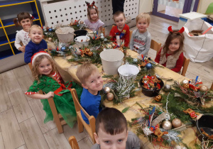 Dzieci wykonują świąteczne stroiki.