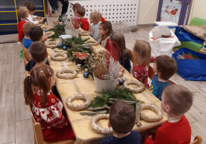 Dzieci wykonują świąteczne stroiki.
