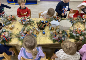 dzieci wykonują stroiki świąteczne