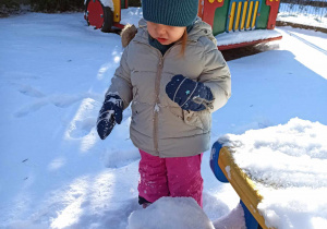 Dziewczynka bawi się śniegiem.