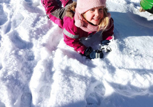 Dziewczynka bawi się na śniegu.