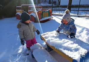 Dzieci bawią się śniegiem.