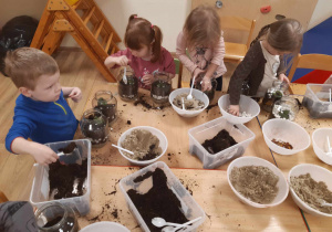 Dzieci wykonują "lasy w słoiku".