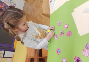 Dziecko robi kwiaty z papieru.