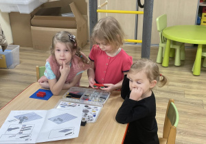 Dzieci konstruują budowlę według instrukcji.