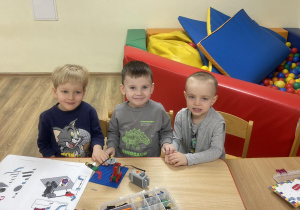 Dzieci konstruują budowlę według instrukcji.