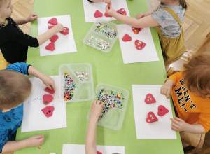 dzieci dekorują kralikami serca z masy solnej