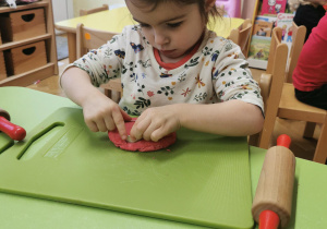 Dzieci robią serca z masy solnej i dekorują je koralikami.