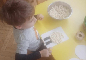 Dziecko wykonuje owieczkę z popcornu.
