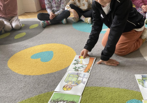 dzieci układają na dywanie obrazki