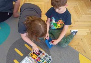 dzieci budują z klocków lego